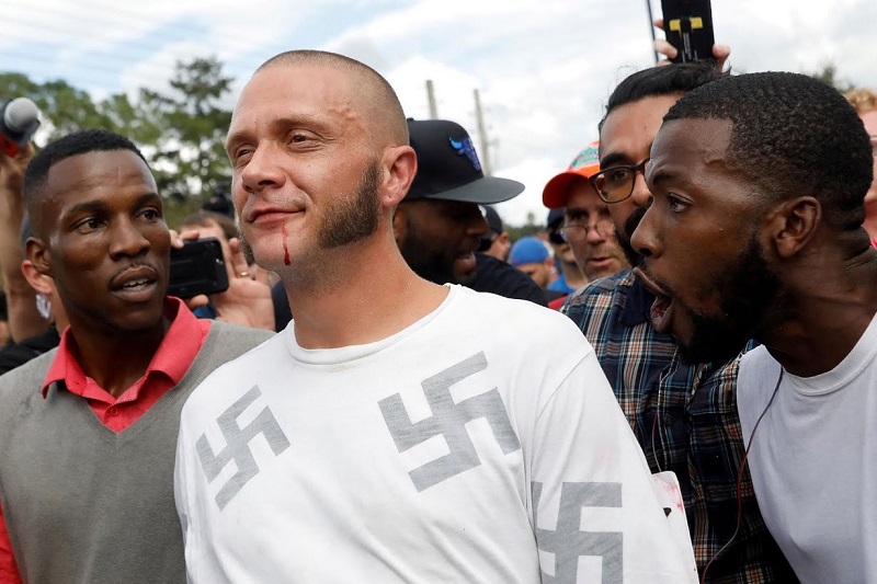 <div>
	Shannon Stapleton: "The evening before Richard Spencer, an avowed white nationalist and spokesperson for the so-called alt-right movement, was to speak at the University of Florida, I walked around the Gainesville campus.</div>
<div>
	All seemed calm; there were no protests. The area was blanketed by police because Florida's governor had declared a state of emergency to try to prevent violence. Early the next day there was a light presence from both sides.</div>
<div>
	Over time, several hundred people protesting Spencer gathered in a "free speech zone" near where he was speaking. Once his speech began, tensions ran high and a few skirmishes broke out, but overall it was peaceful. I sat to file my photos and suddenly people started running.</div>
<div>
	I grabbed my cameras and followed them. In the midst of an angry crowd stood a man in a shirt printed with swastikas. The atmosphere was vitriolic. He had been punched in the face and was smirking as blood trickled down his chin.</div>
<div>
	He had walked right into the free speech zone and this really physical crowd. I got in there and took my photo as police were trying to escort him out of the zone. People called him pejorative names; some spat at him.</div>
<div>
	It was almost surreal. A black man stepped beside him and guided him out of the crowd and over the barricade, alternately speaking to him and shouting at him. I moved with them and watched as the man went off, seeming to disappear."</div>

